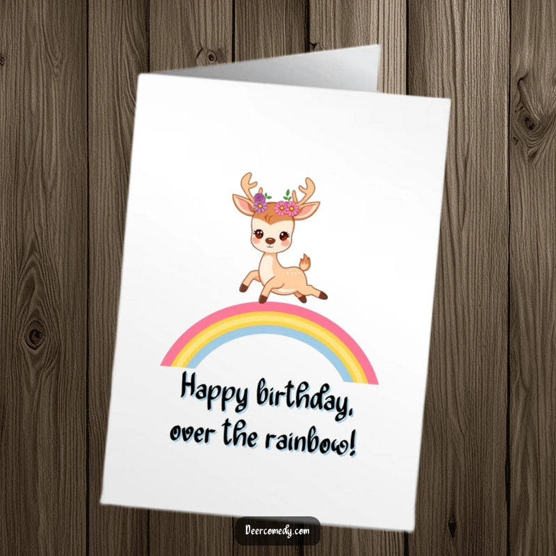 Funny Free Printable Birthday Card: A cute deer with flowers in its antlers joyfully bounds over a vibrant rainbow, celebrating.